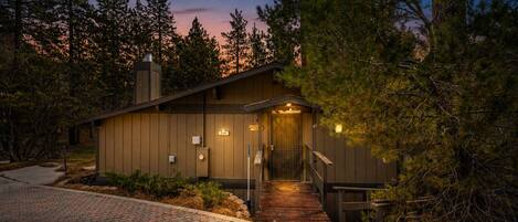 A lodge with a wooden exterior, a covered entrance, and a paved driveway.