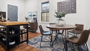 Una cocina moderna con una mesa de madera, sillas y un florero decorativo.