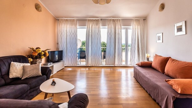 A living room with a sofa, a TV, and a coffee table.