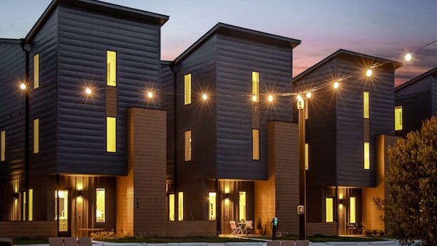 A modern building with multiple units, outdoor seating, and a fire pit.