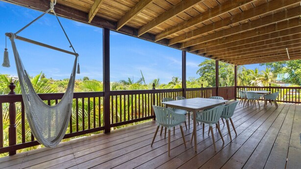 A wooden deck with a hammock, tables, and chairs. - Dos Culebras House-Private Pool (Puntas)