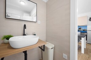 Regadera, secadora de cabello, toallas, papel de baño 