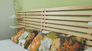 A bed with a wooden headboard and floral-patterned pillows. - Rickymary House, Pet Friendly (Senigallia)