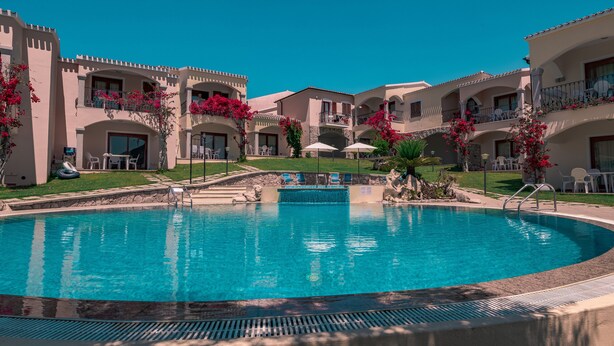 A swimming pool surrounded by a courtyard with multiple buildings, each with balconies and outdoor seating. - The Fantastic Residenza Badus 1 Bedroom Apartment B4 Sleeps 4 (Badesi)