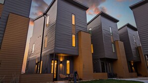 Un moderno edificio residencial con tejado plano, ventanas amplias y una entrada bien iluminada.