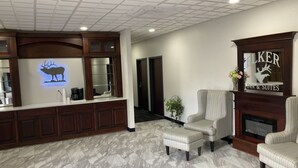 Hall d'albergo con reception, camino e zona salotto.