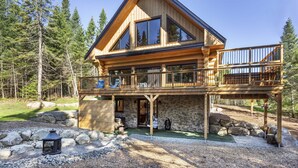 A log cabin with a balcony, stone foundation, and a view of the surrounding forest. - Tremblant Luxury Chalet-Hot Tub, dry Sauna, Pool table, Fireplace & Lake Access (Lac supérieur)