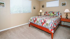 Quarto com uma cama, duas mesas de cabeceira e uma janela com persianas.