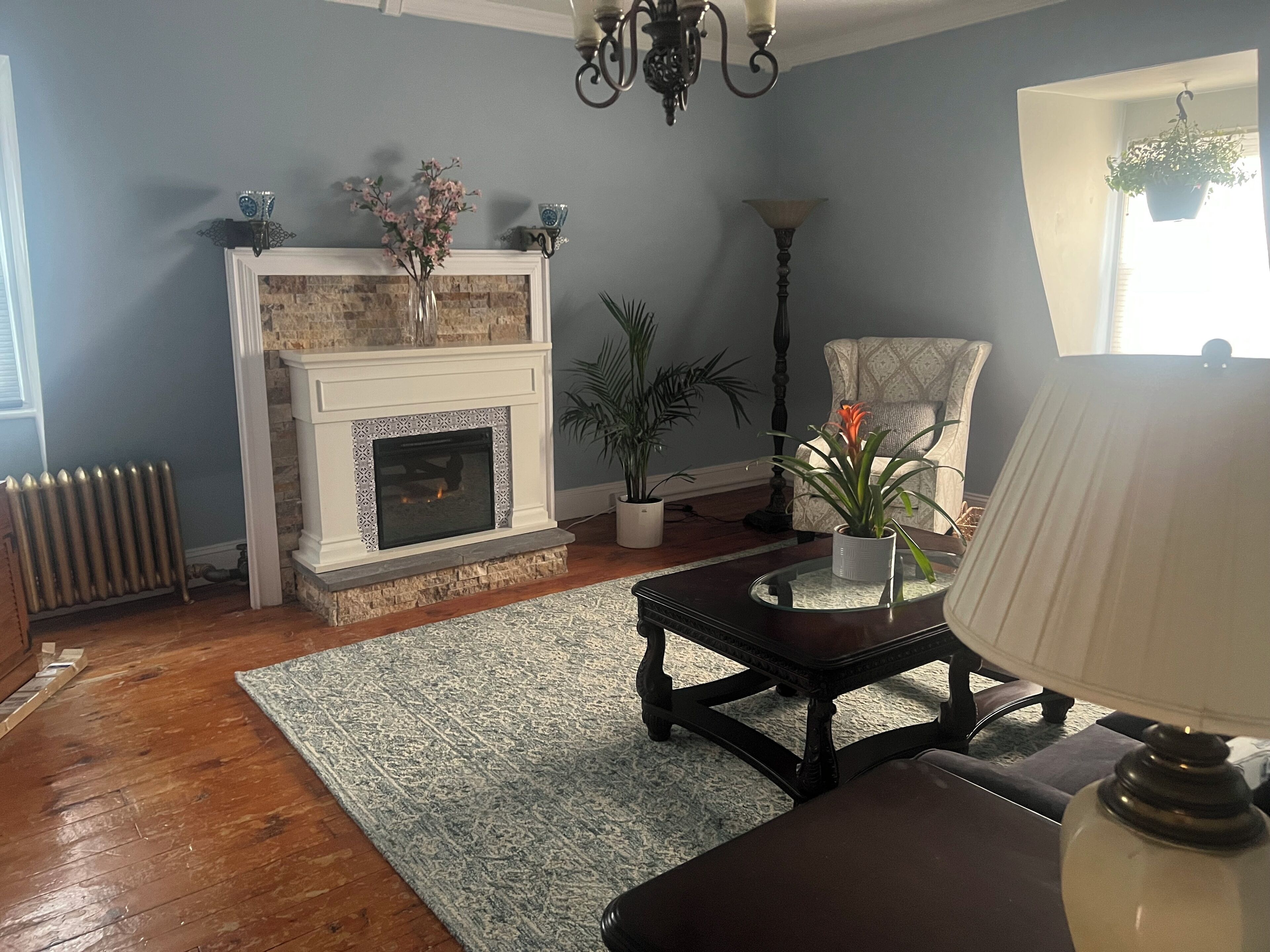 A living room with a fireplace, a sofa, a coffee table, and a lamp.