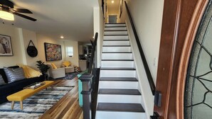 A modern living room with a staircase leading to an upper level. - Fairview Terrace-Brand New 3BDRM, Central Location  (Atlantic City)