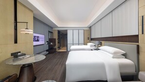 A modern hotel room with a large bed, a round table, and a TV on the wall. - Zhuhai Marriott Hotel Jinwan (Zhuhai)