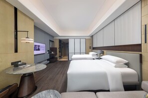 A modern hotel room with a large bed, a round table, and a TV on the wall. - Zhuhai Marriott Hotel Jinwan (Zhuhai)