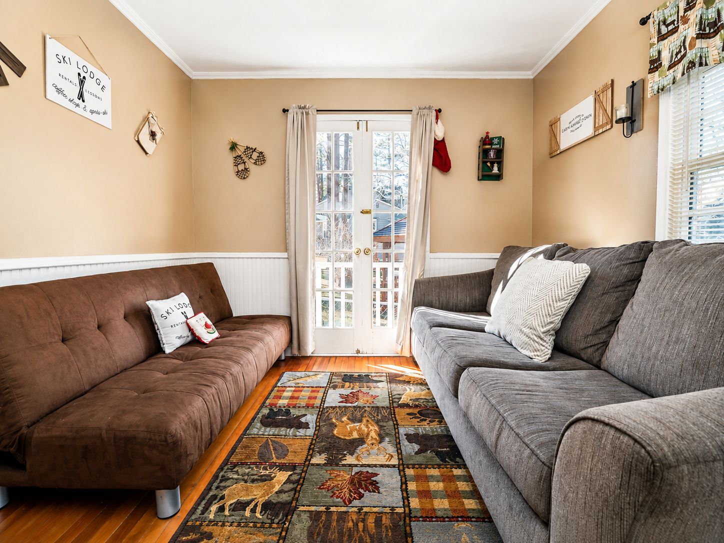 A cozy living room with two sofas, a patterned rug, and a door leading outside.
