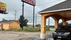 A motel with a large sign advertising roadside assistance. - Roadside Inn (Floresville)