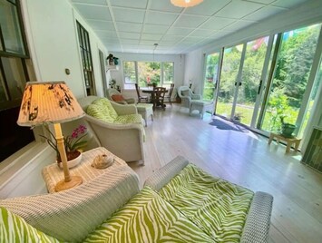 Sunporch overlooks sunny open back yard and garden. 
