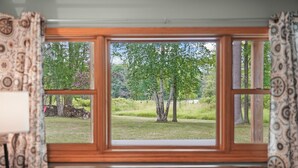 Una habitación con un gran ventanal que ofrece vistas a un espacio verde con árboles.