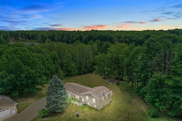Exterior Retreat: Nestled among lush trees, enjoy nature's embrace and vibrant sunsets!