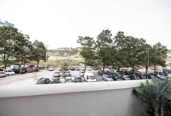 A parking lot with multiple cars and a few trees.