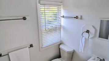 Banheira, secador de cabelo, toalhas de banho