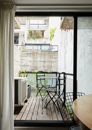 A balcony with a wooden floor, metal chairs, and a table. - Hestia at Armenia 1900 (Buenos Aires)
