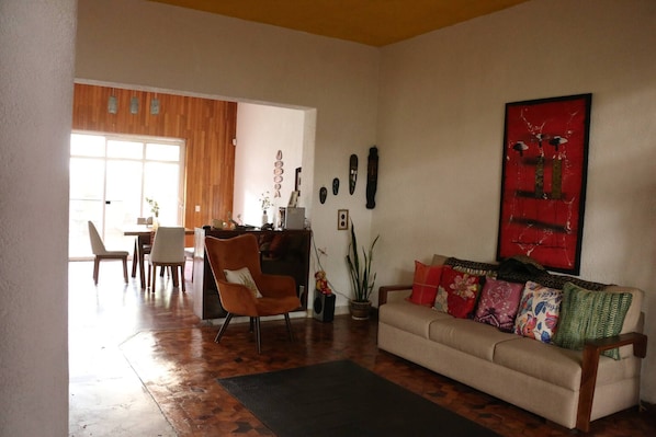 A living room with a sofa, chairs, a coffee table, and a dining area with a table and chairs.