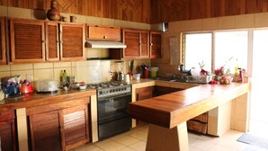 A kitchen with wooden cabinets, a stove, and a large island.