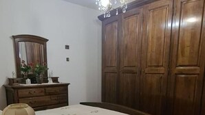 Ein Schlafzimmer mit Bett, Kommode, Spiegel und einer Chandelier.