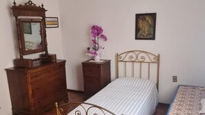 Ein Schlafzimmer mit Bett, Schminktisch, Kommode und einer Chandelieber.