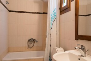 A bathroom with a bathtub, a sink, and a shower curtain. - Octopus House 1 min From the Beach of Nikiti (Sithonia)
