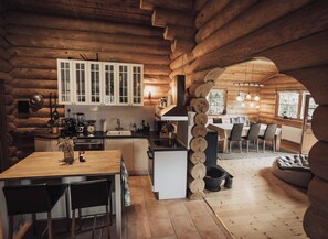 A log cabin interior with a kitchen, dining area, and a cozy seating space. - Fjordhygge, Cozy Log Retreat Near Sea & Forest - Sauna & Outdoor Living (Jægerspris)