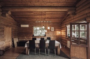 A log cabin interior with a dining area, wooden ceiling, and a window with a view. - Fjordhygge, Cozy Log Retreat Near Sea & Forest - Sauna & Outdoor Living (Jægerspris)