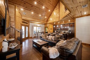 Cozy living area with a leather sofa, dining table, and mounted TV.