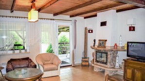 A cozy living room with a fireplace, comfortable seating, and a television.