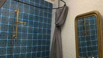 Un baño con bañera, lavabo, espejo y candelabro.