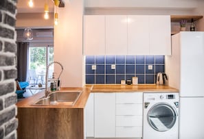 Enjoy cooking in this well-lit kitchen with a washing machine and large window.