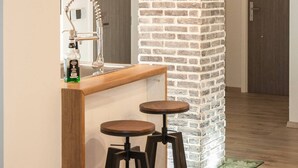 Eine Bar mit Hockern, einem Spiegel und einer Wand aus Ziegelsteinen.