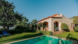 A stone building with a swimming pool, a lawn, and a clear blue sky. - Villa Arianna With Breathtaking View Near Rethymno (Rethymno)