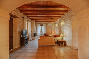 Ein gemütliches Wohnzimmer mit Kamin, Sofa und Fernseher.