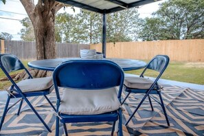 A covered patio with a round table and four blue chairs with cushions. - LET D'S COZY COTTAGE #2 PROVIDE YOU A COMFORTABLE STAY IN BIG SPRING, TEXAS!!! (Big Spring)