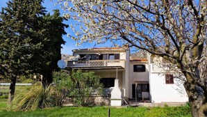 Un immeuble de deux étages doté d’un balcon, d’une antenne parabolique et d’un petit hall d’entrée.