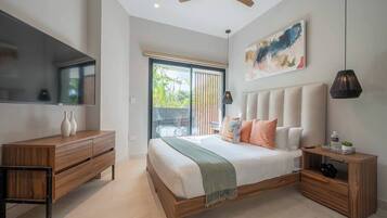 A bedroom with a bed, a wooden dresser, a TV, and a ceiling fan.