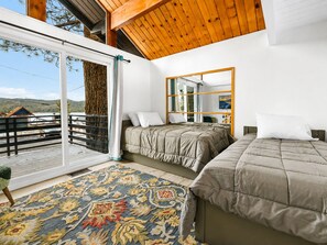 A bedroom with two beds, a large window, and a view of the outdoors. - Big Bear Lake View (Big Bear Lake)