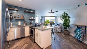 A modern kitchen with a central island, stainless steel appliances, and a view to the outdoors.