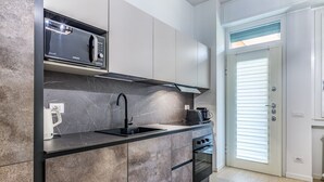 A modern kitchen with a built-in microwave, a sink, and a stove. - Pisani Apartment Milano Repubblica (Milano)