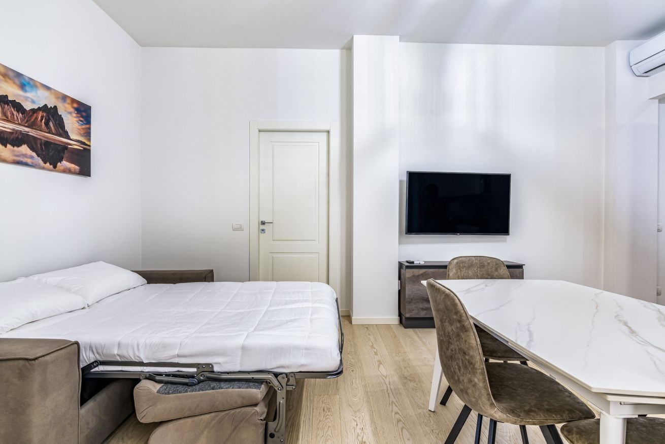 Une chambre moderne équipée d’un lit, d’une table à manger et d’un téléviseur.