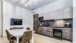 A modern kitchen with a dining area, built-in appliances, and a flat-screen TV. - Pisani Apartment Milano Repubblica (Milano)