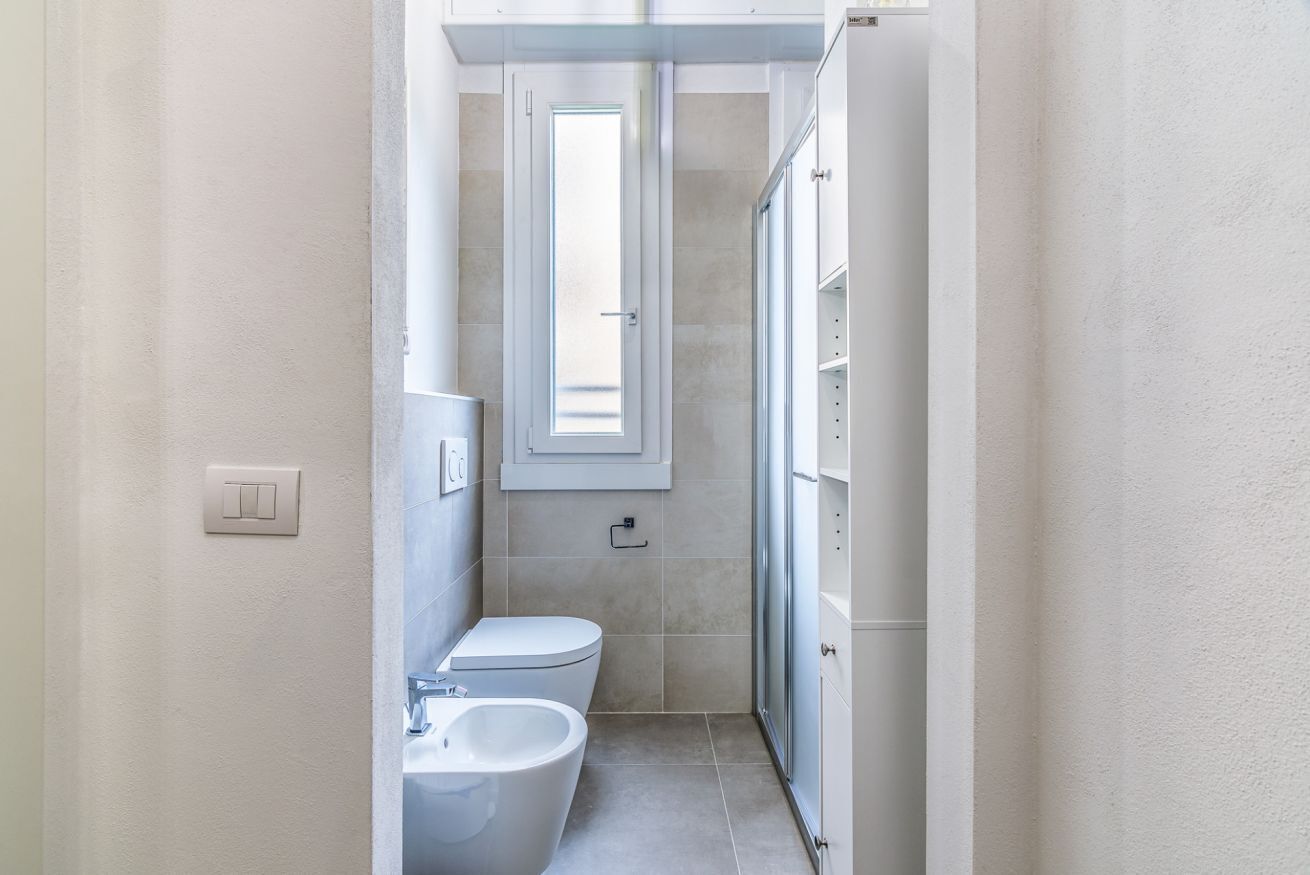 Une petite salle de bain comprenant des toilettes, un bidet et une petite fenêtre.