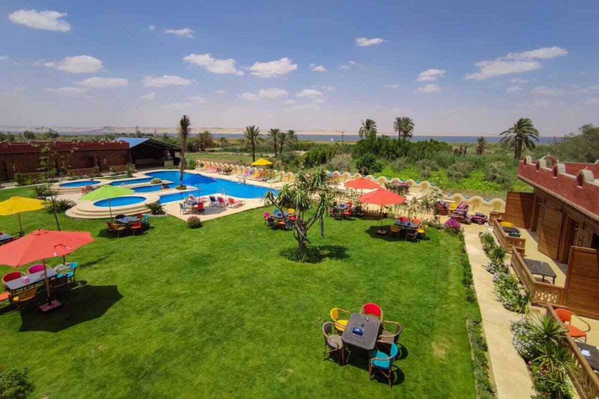 Uma área de piscina com várias piscinas, espreguiçadeiras e guarda-sóis.