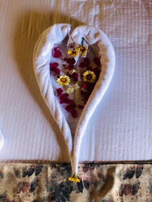 A heart-shaped towel with dried flowers.