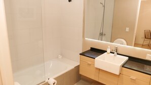 A modern bathroom with a bathtub, a sink, and a mirror. - Silencioso Studio en Palermo Hollywood (Buenos Aires)